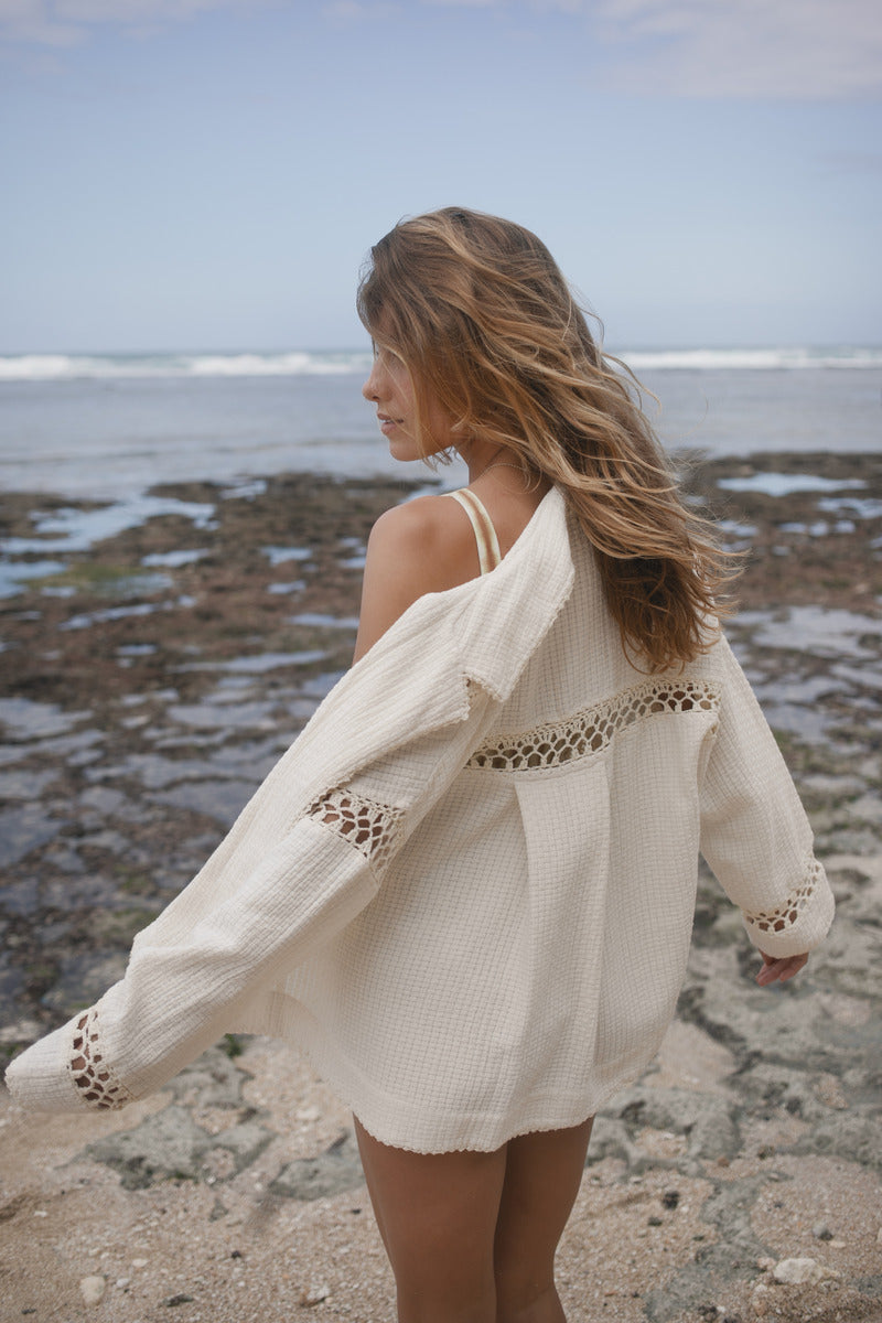 Model wearing white cotton shirt with crochet detailing