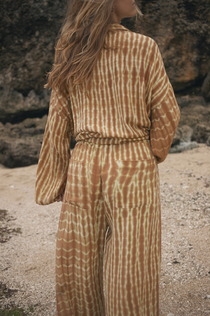 Womens tan cotton tie dye pant, styled with matching shirt, back view
