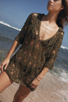 Woman wearing a crochet cover-up mini dress on a beach