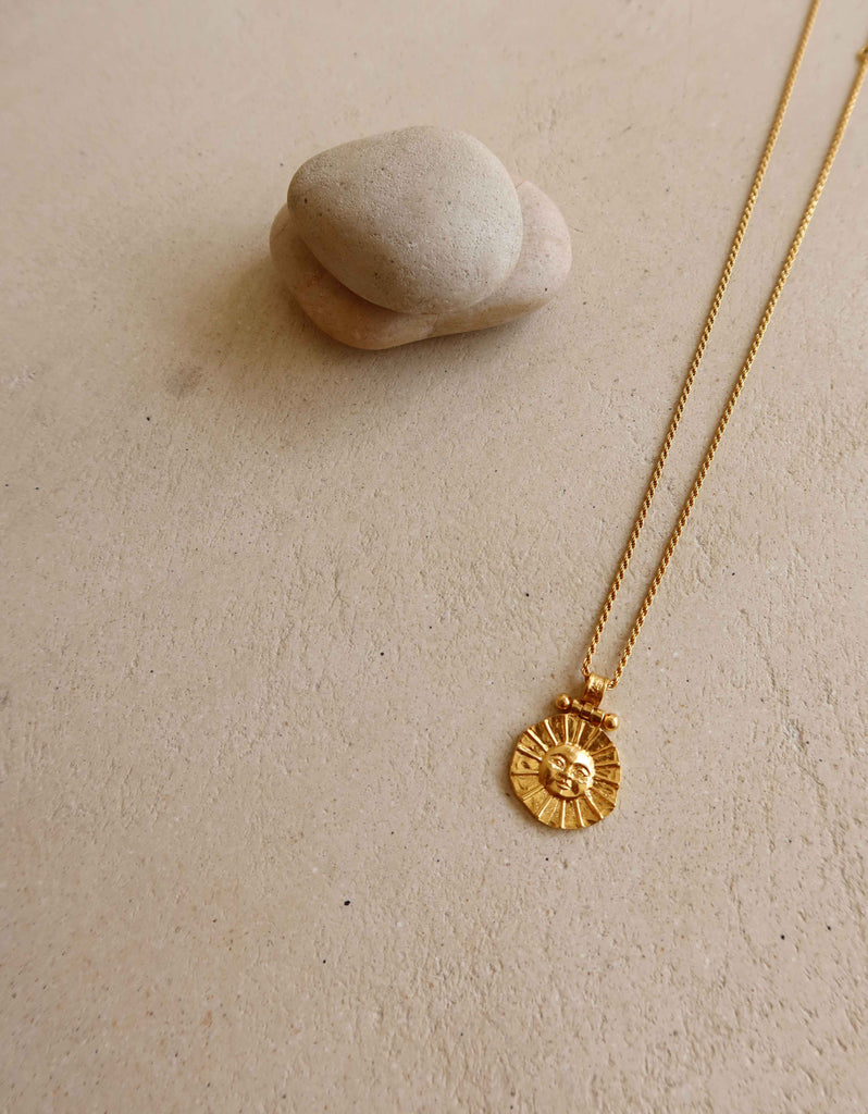 gold plaited necklace with sun motif pendant