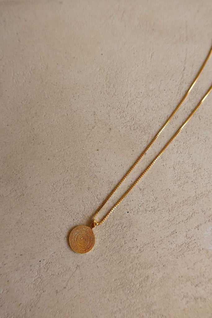 gold plaited necklace with swirl motif pendant 
