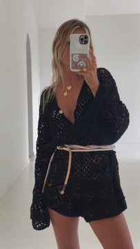 model wearing black long sleeve crochet jumpsuit with belt 